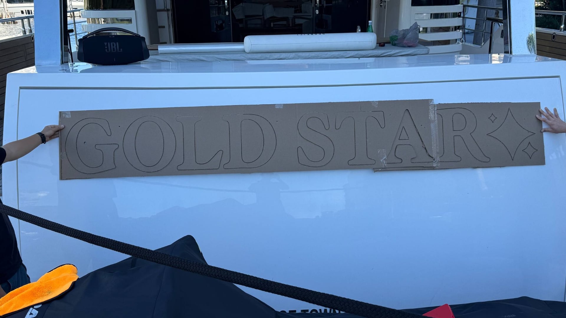 Cardboard GOLD STAR template held on the yacht transom for fitment